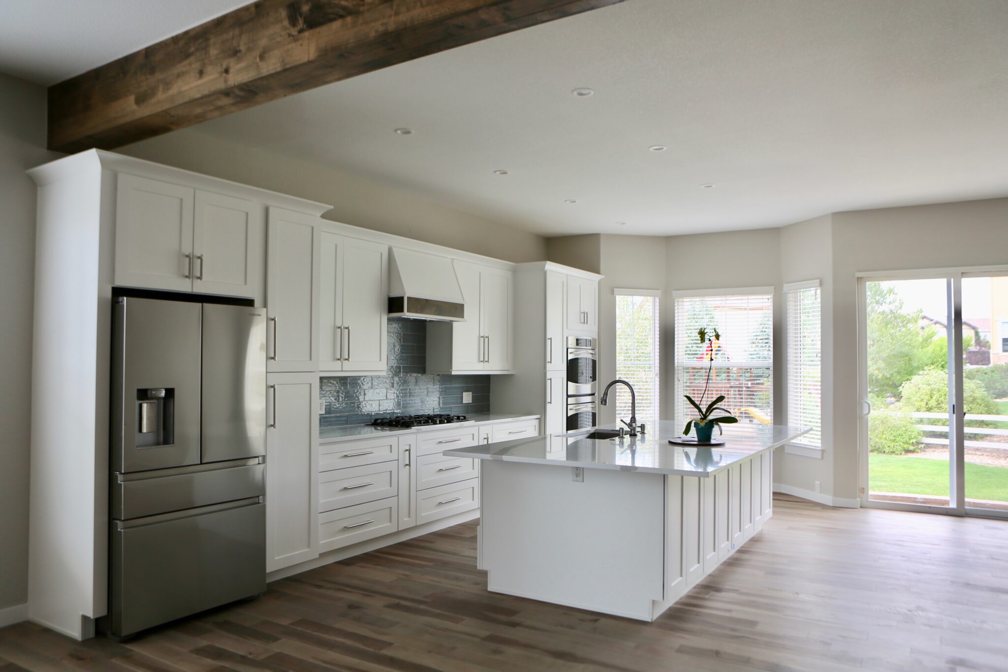 Open-concept kitchen with exposed wooden beam and natural light